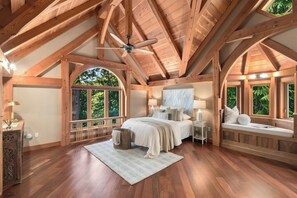 A spacious bedroom with a large bed, a ceiling fan, and multiple windows offering views of the outdoors. - Private Luxury 4 Bedroom Estate on 4 Acres with over 1,100 feet of shoreline! (Orcas)