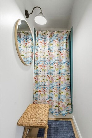 A bathroom with a shower curtain featuring a nautical theme, a wall-mounted mirror, and a bench. - Keuka Lakefront - 2 Homes Captain's Quarters & Crow's Nest - Hot Tub/Kayaks/SUPs (Penn Yan)
