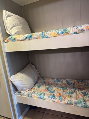 A bunk bed with white pillows and a floral-patterned bedspread. - Cozy 1-bedroom condo in peaceful Hilton Head Island with private beach access (Hilton Head Island)