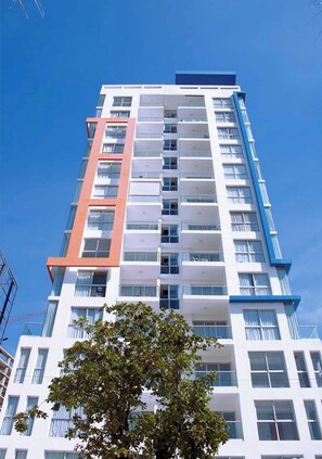 A multi-story building with a modern architectural design, featuring balconies and large windows. - Apartment with an ocean view in the heart of the city (Santo Domingo)