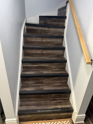 A staircase with dark wooden steps and white walls. - Executive Stay - Near Airport (Brampton)