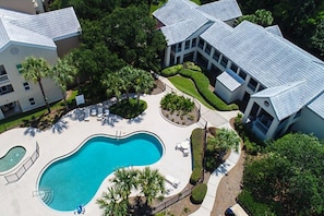 An aerial view of a residential area with a swimming pool, multiple houses, and well-maintained gardens. - BLOCK Bayside 2br (Panama City Beach)