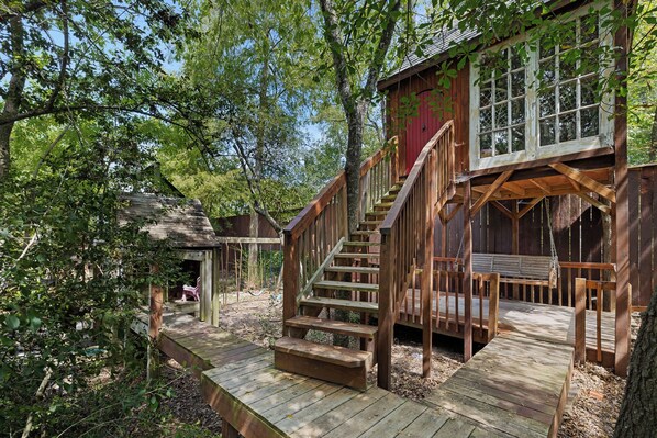 Eine Holzhütte mit einer Holztreppe, die zu einer Terrasse führt.
