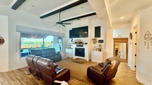 A living room with leather chairs, a fireplace, a television, and a view of the outdoors. - Stay near Randolph AFB! Perfect for military families, TDY & vacationers (Saint Hedwig)