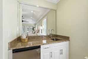 A kitchen with a granite countertop, a dishwasher, and white cabinetry. - Steps to the Beach! 3BR w/Gulf Views! Pool*Jacuzzi (Fort Myers Beach)