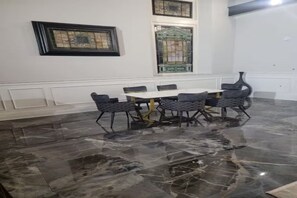 A dining area with a marble floor, a white table, and grey chairs. - Luxurious 6-Bedroom Estate & Executive Retreat Dayton Area (Dayton)