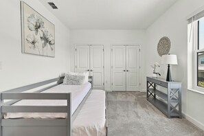 A bedroom with a bed, a dresser, a mirror, and a door. - The Luxe Nova - Private Heated Pool/Hot tub and Grill included (Melbourne Beach)