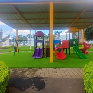 A playground with slides and a covered area.