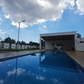 A swimming pool with a clear blue sky and clouds in the background. - 5 Min to Hot Springs • Family Home with Hammock (Ahuachapán)