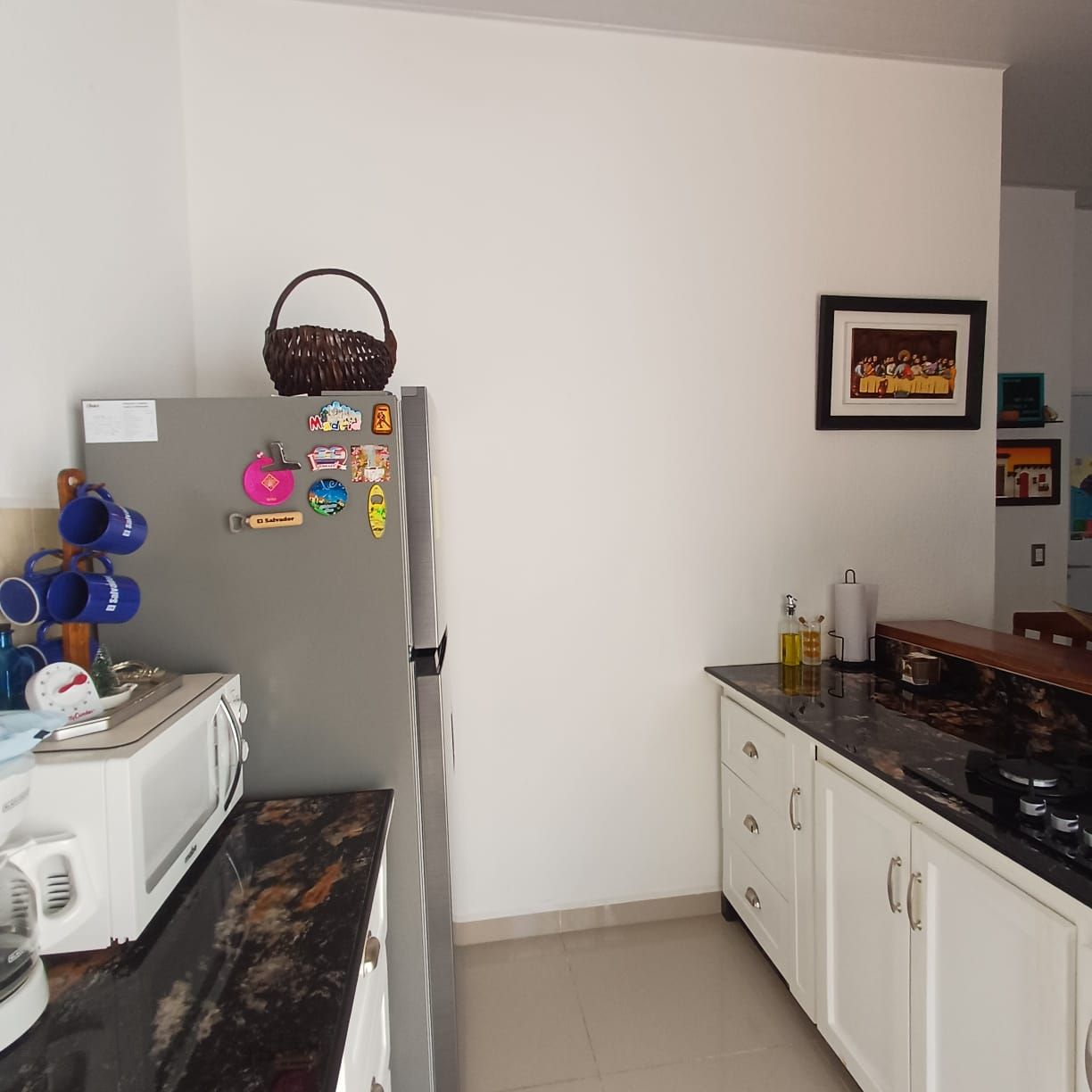 Una cocina equipada con refrigerador, microondas y pileta.