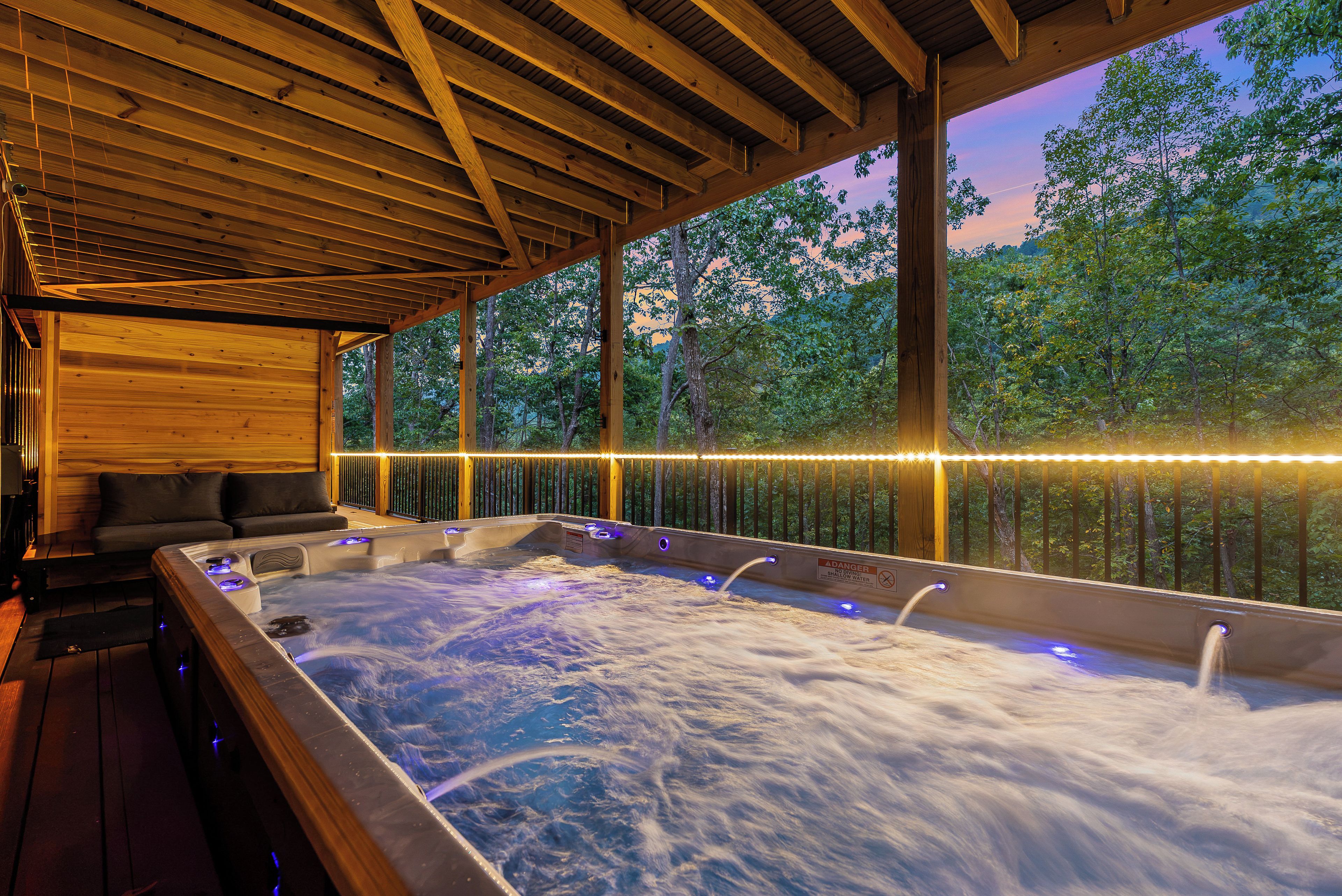 A hot tub area with wooden beams and a view of trees.