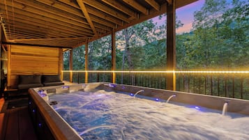 A hot tub area with wooden beams and a view of trees.