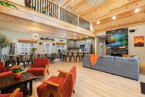 Amplia sala de estar con techo alto, comedor con vistas y cocina equipada con electrodomésticos modernos.