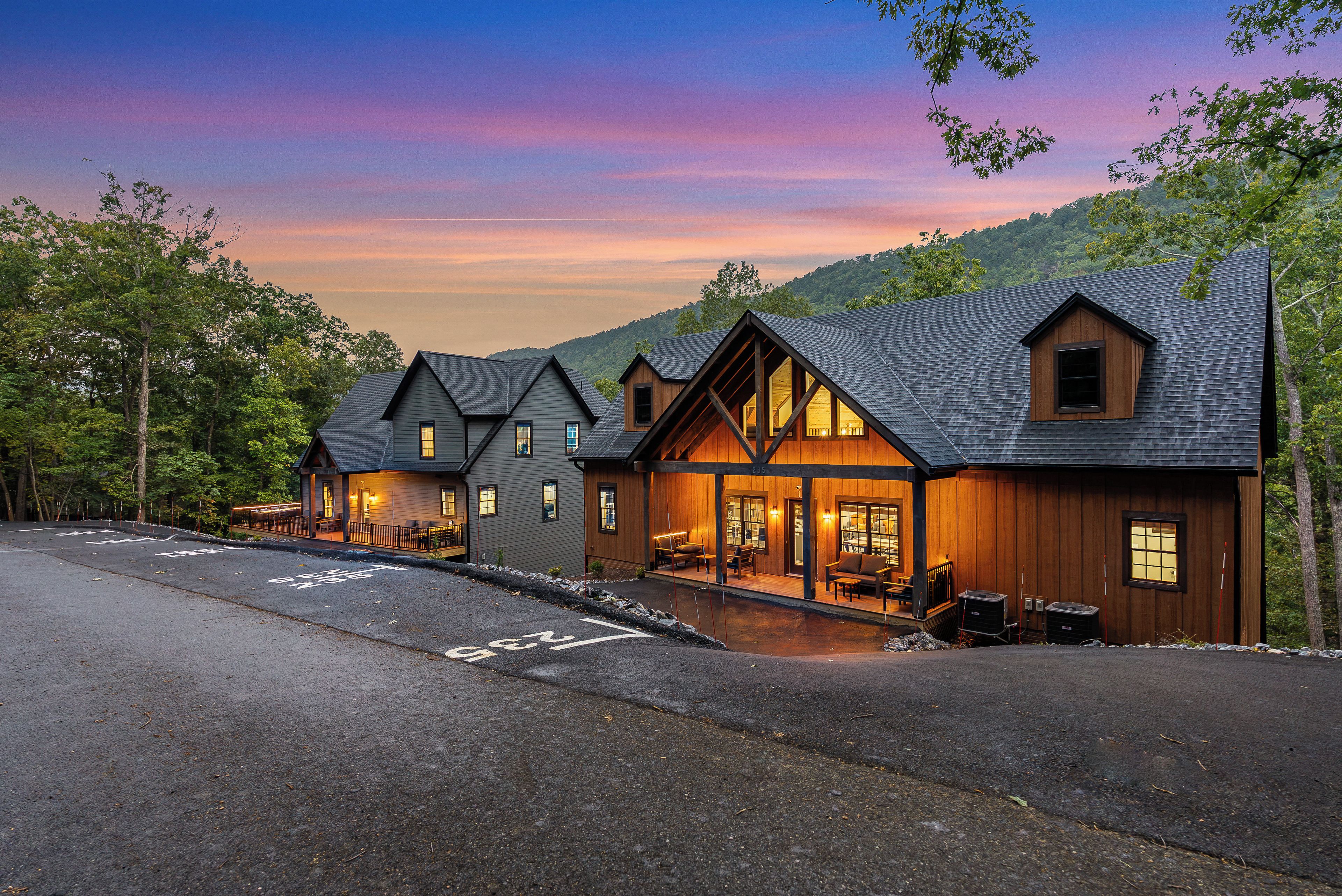 A lodge with a covered outdoor seating area and a view of the surrounding forest.