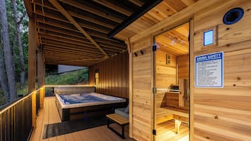 A wooden sauna with a hot tub, a safety sign, and a view of the surrounding forest.