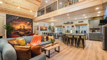 A spacious living area with a high ceiling, a dining area, and a kitchen.