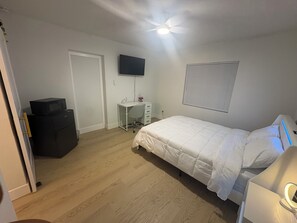 A bedroom with a bed, a desk, a TV, and a wardrobe. - Welcoming 1-bedroom apartment with AC in vibrant Tampa (Tampa)