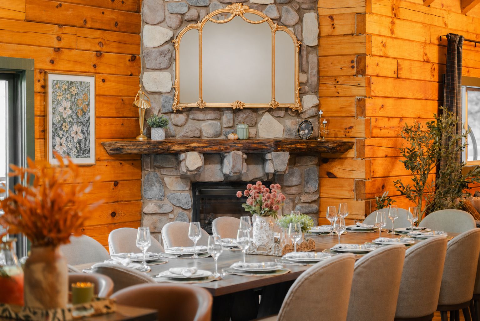 A dining area with a stone fireplace, wooden walls, and a table set for six with chairs.