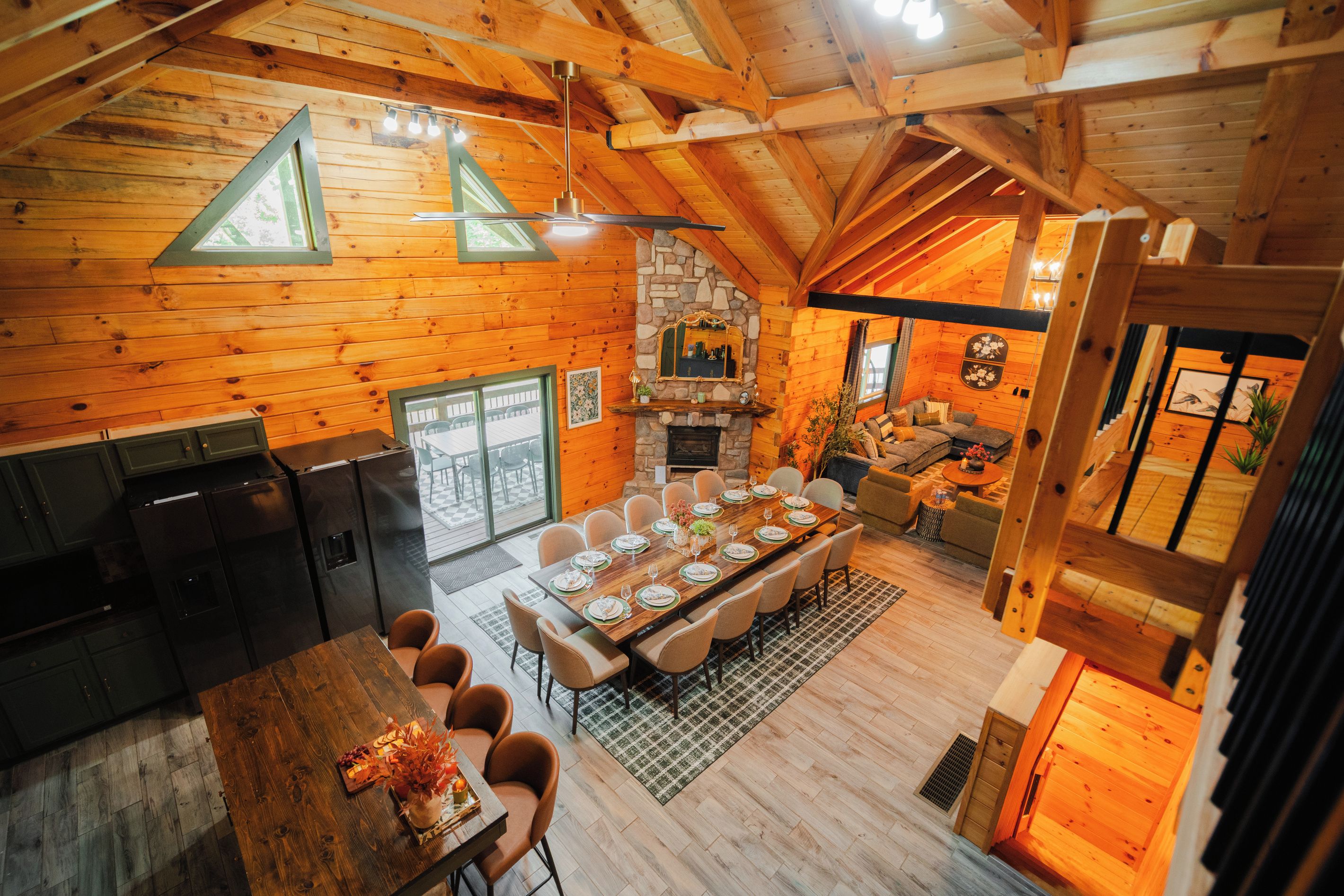 A wooden cabin interior with a dining area, kitchen, and living space.