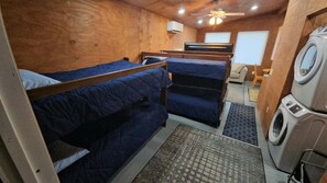 A compact RV interior with bunk beds, a washing machine, and a ceiling fan. - Base Camp on Cherry Hill — Fife Lake, MI 

Cabin, Sleeps 4–8 (Fife Lake)