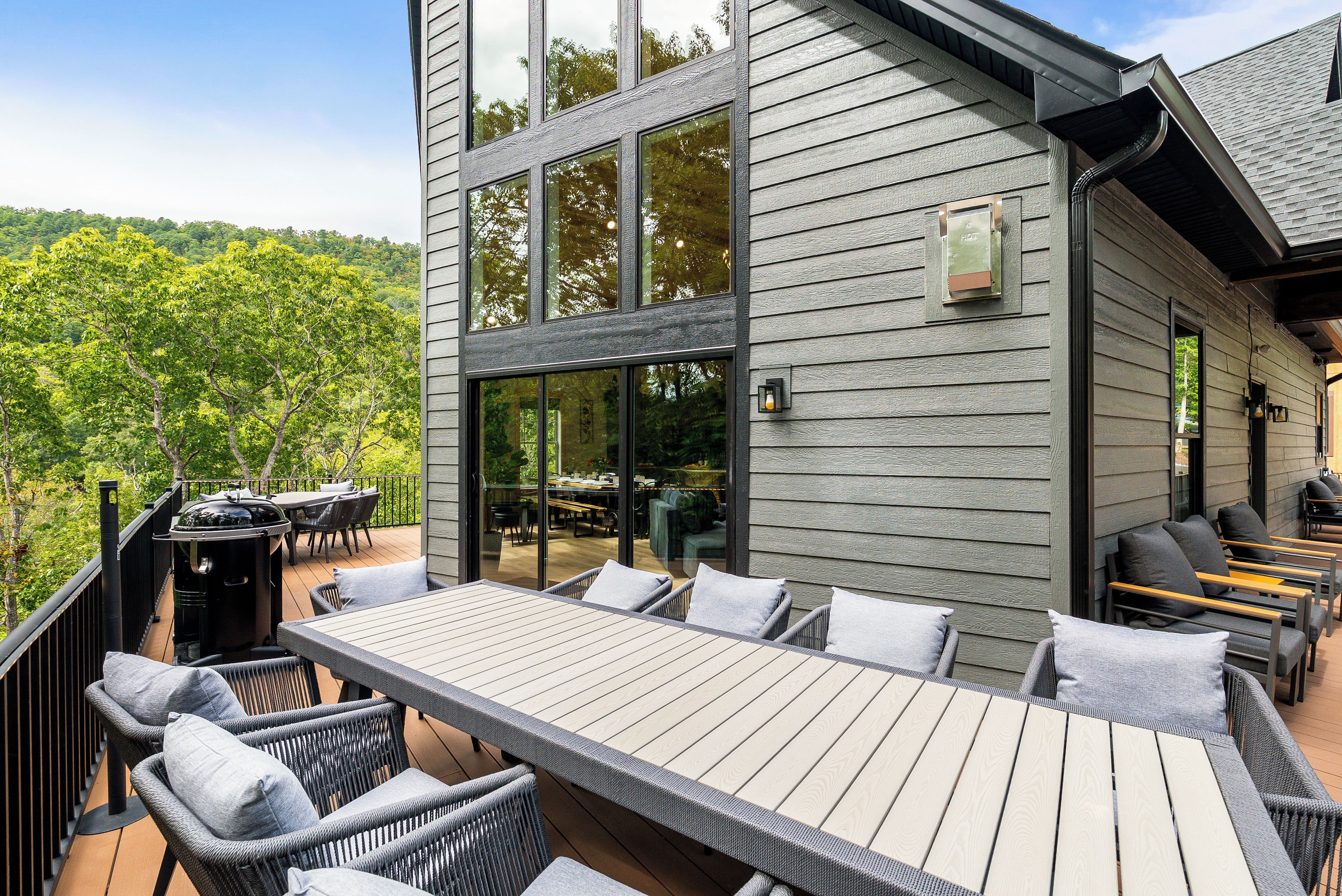 Une terrasse extérieure avec une table et des chaises, donnant sur une zone boisée.