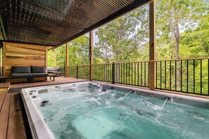 Un jacuzzi con terraza de madera y vistas a árboles.