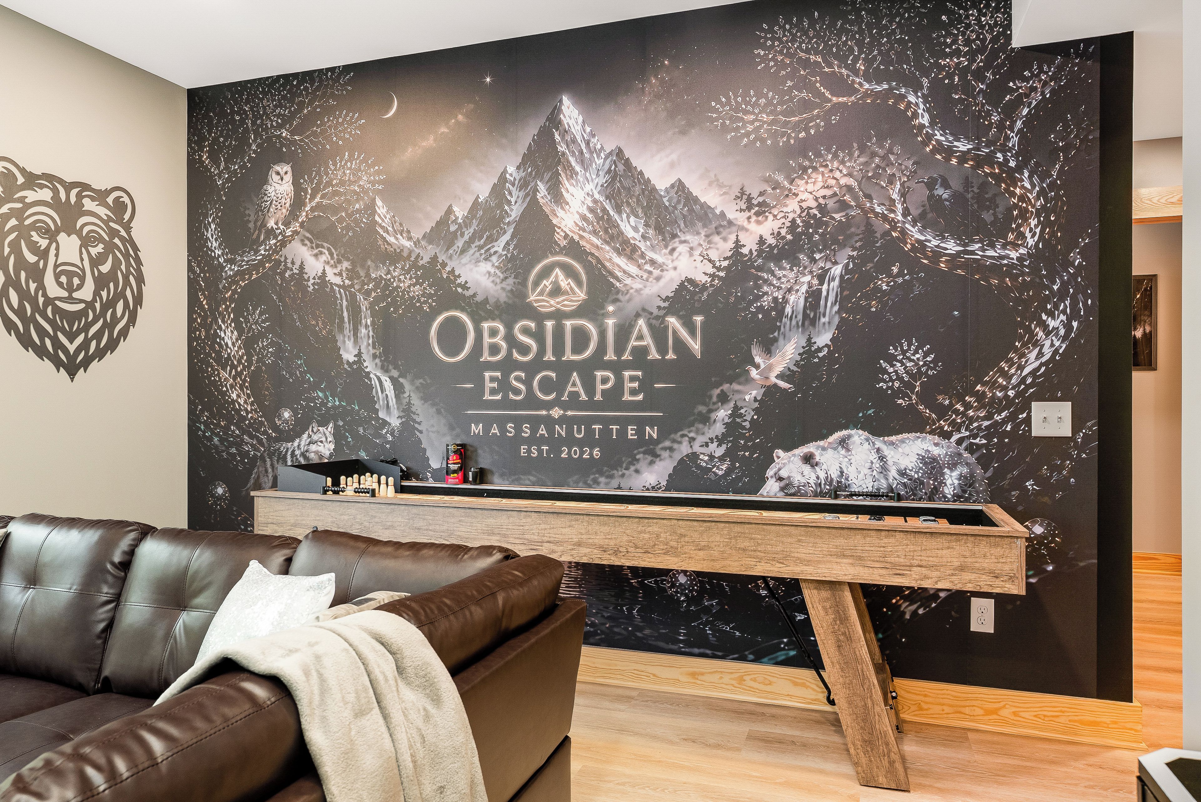 A modern living room with a large wall mural titled 'Obsidian Escape,' a brown leather sofa, and a wooden coffee table.