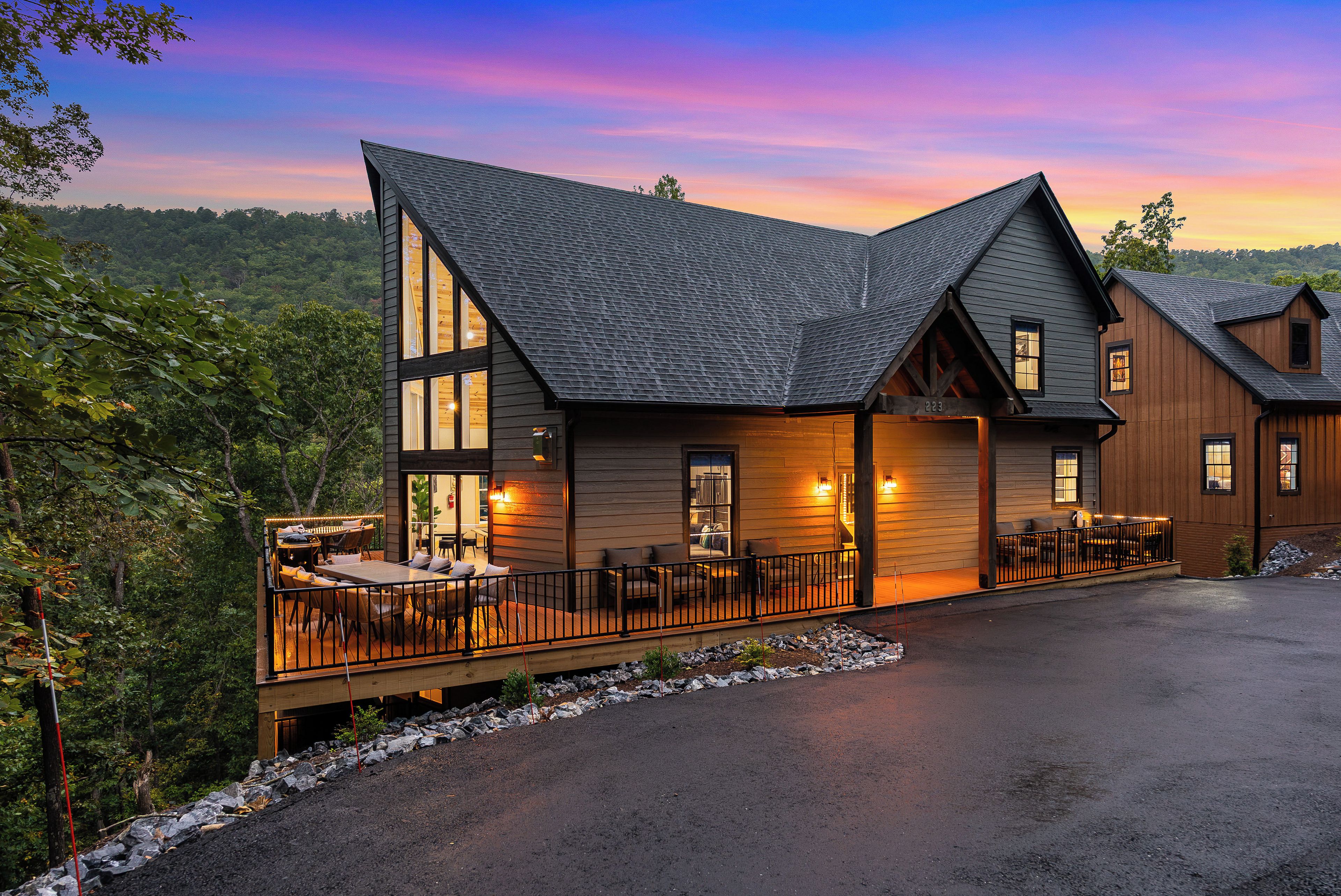 A two-story lodge with a deck and outdoor seating area.
