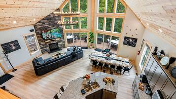 A spacious living area with a large L-shaped sofa, a dining table set for six, and a kitchen with granite countertops.