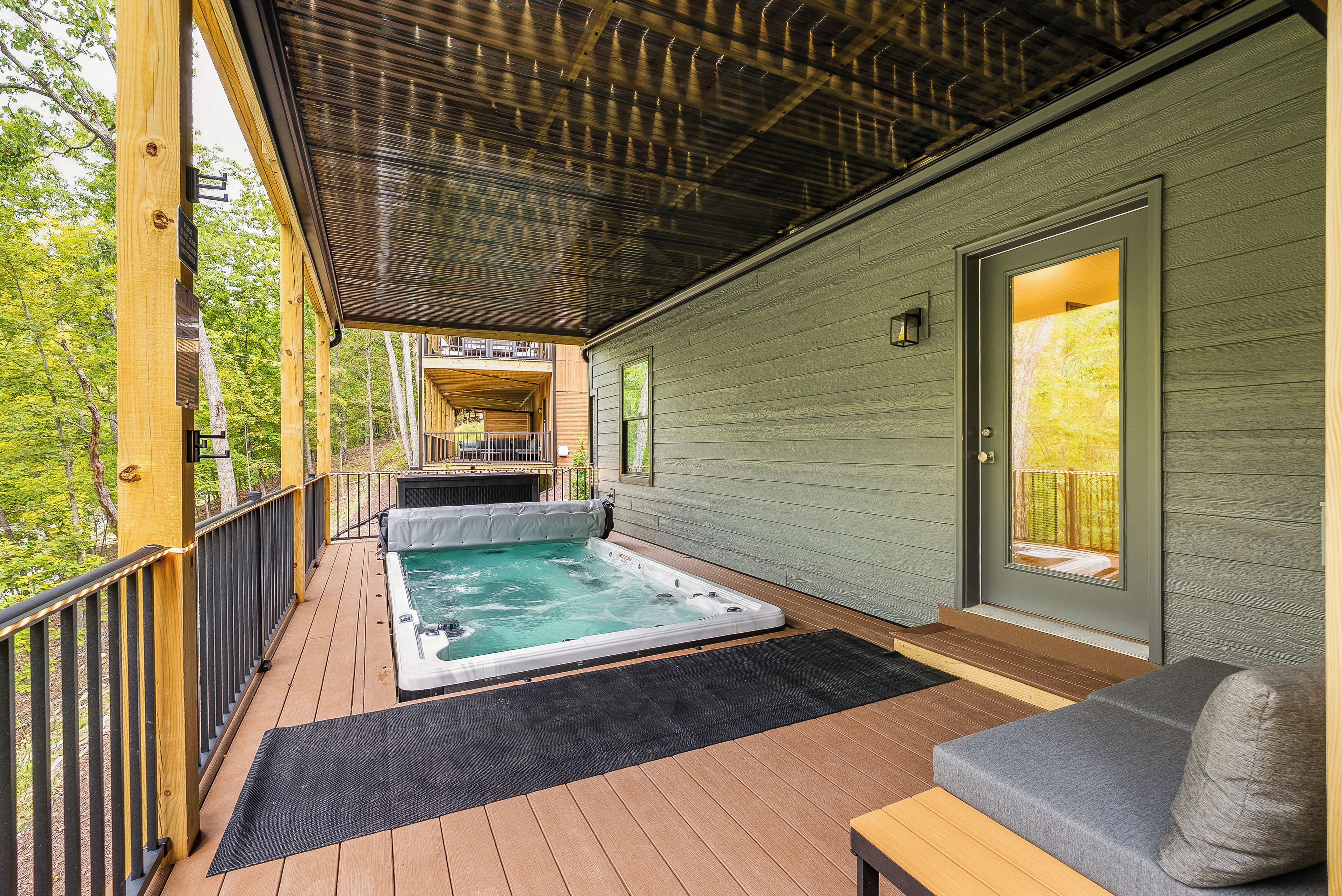 A wooden deck with a hot tub and outdoor seating.