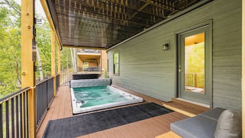 A wooden deck with a hot tub and outdoor seating.