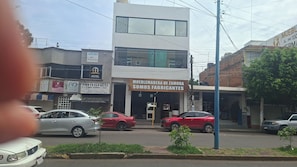 A street view with a two-story building housing a furniture workshop. - A1 Cuadra Historic Center New Apartment 2 Bedrooms 24/7 Parking (La Piedad de Cabadas)