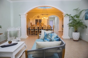 A spacious living area with a dining table, chairs, and a sofa with patterned cushions. - Big House with Yard Near the Beach - Daily Cleaning (Cartagena de Indias)