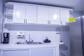 A kitchen with white cabinets, a stainless steel sink, a coffee maker, and a refrigerator. - Big House with Yard Near the Beach - Daily Cleaning (Cartagena de Indias)