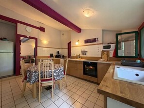 A compact kitchen with a dining table, a microwave, a sink, and a refrigerator. - XIXTABERRI - CAMBO-LES-BAINS (CAMBO-LES-BAINS)