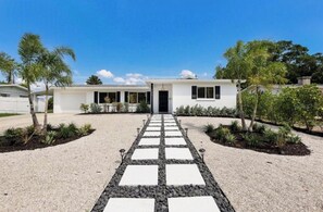 A modern two-story house with a gravel driveway and a stone pathway leading to the front door. - Chic 2-Bedroom Home with Heated Pool + Bar close to AMI/IMG (Bradenton)