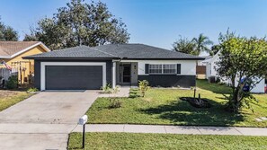 A single-story residential house with a garage, a front lawn, and a mailbox. - 2BR Quiet House-king TempurPedic Matress-BBQ-Garden (Palm Harbor)