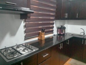 Una cucina con piano cottura a gas, macchina del caffè e lavandino.