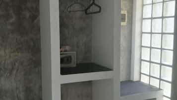 Une chambre dotée d’un réfrigérateur encastré, d’un portant à vêtements et d’une fenêtre à carreaux.