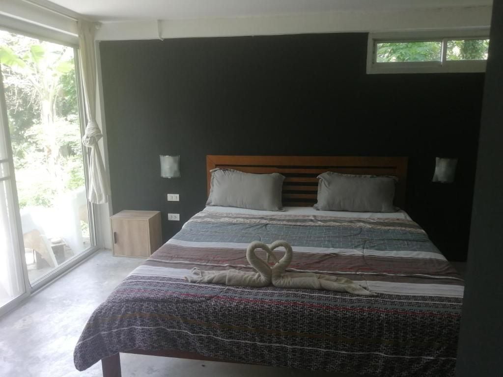 Un dormitorio con una cama grande, una ventana con cortinas y vistas al exterior.
