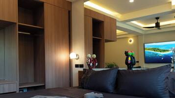 A hotel room with a bed, a TV, and built-in wooden storage units.