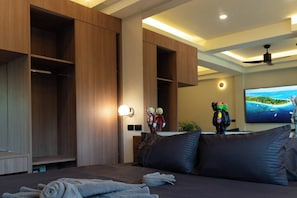 Une chambre d’hôtel équipée d’un lit, d’une télévision et de meubles de rangement en bois intégrés.