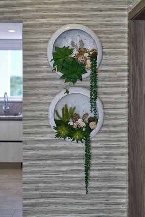 Una pieza decorativa montada en la pared con dos elementos circulares que contienen plantas y conchas.