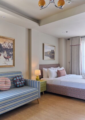 A hotel room with a bed, a sofa, a nightstand, a lamp, and two framed pictures on the wall. - LangX Heaven Hotel & Apartment (Ngu Hanh Son)