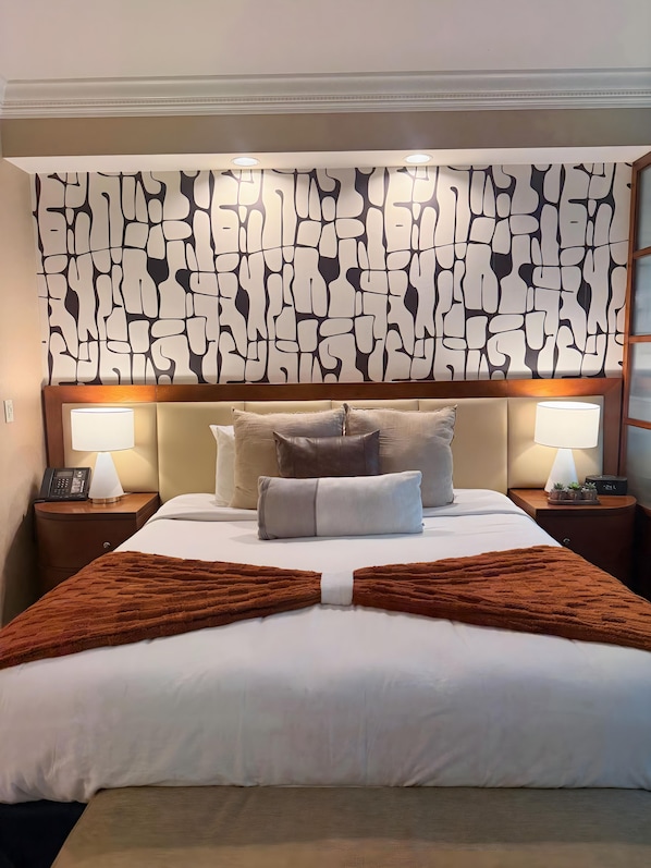 A hotel room with a large bed, two bedside lamps, a telephone, and a wall with a unique abstract pattern. - Sphere Suite MGM Signature (Las Vegas)