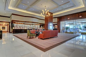 A spacious lobby with a reception desk, seating area, and a large chandelier. - Sphere Suite MGM Signature (Las Vegas)