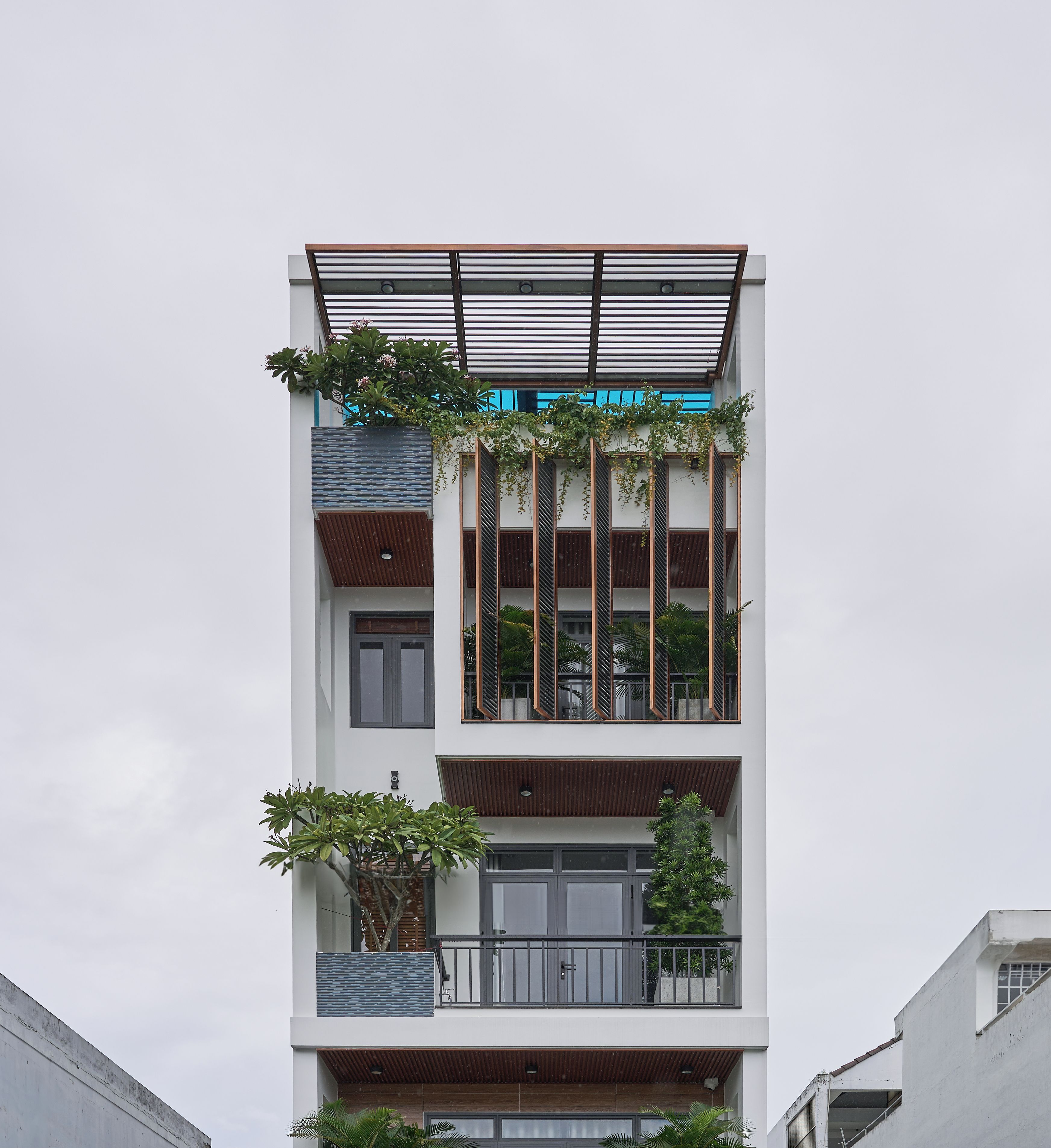 A multi-story building with balconies, large windows, and a flat roof.