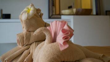 Une serviette ornée d’une fleur et un objet décoratif posés sur une surface en bois.
