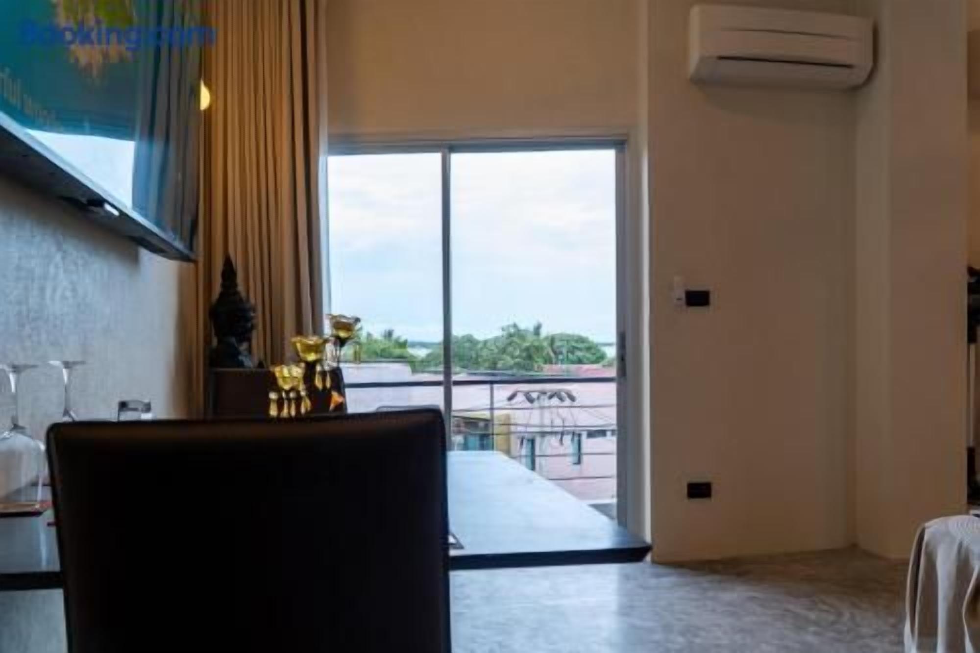 Une chambre d’hôtel dotée d’une grande fenêtre, d’un téléviseur à écran plat fixé au mur et d’une table avec une chaise.