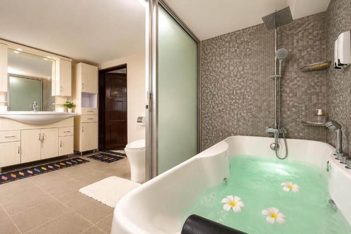 A modern bathroom with a freestanding bathtub, a shower, and a toilet.